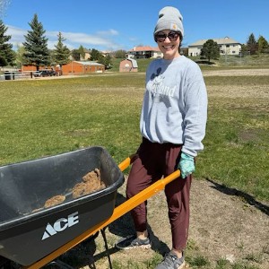 Teacher wheeling mulch in a wheel barrow